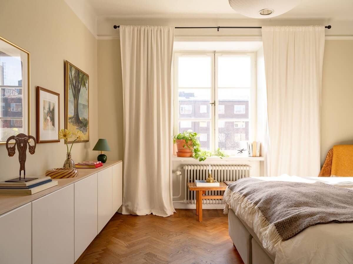 A Stockholm Apartment with Bright Green Color Accents 12 serene bedroom with beige walls and floating cabinets