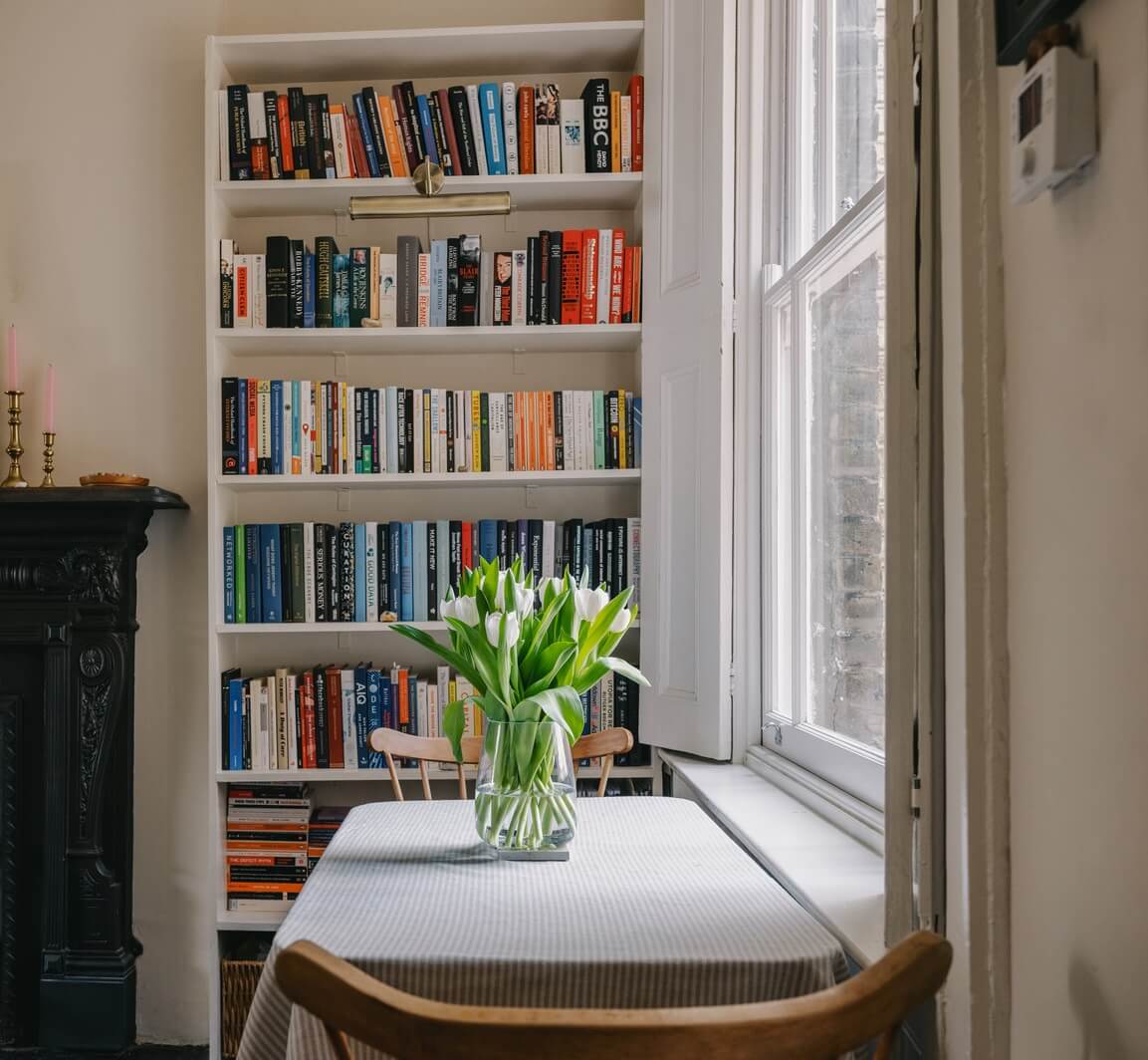 A Small London Apartment Filled with Books 5 small dining table in front of the window
