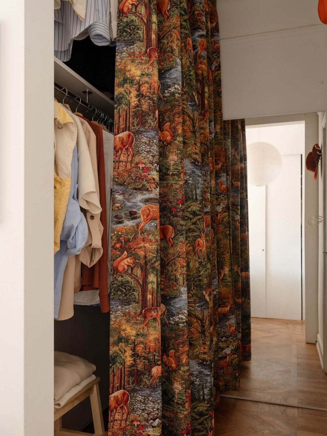 A Stockholm Apartment with Bright Green Color Accents 16 wardrobe hidden by patterned curtain