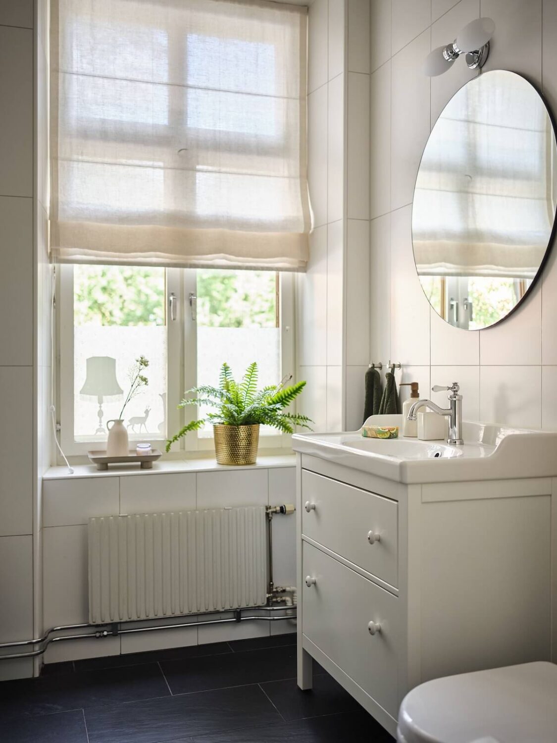 A Classic Stockholm Apartment with Floral Wallpaper 28 white bathroom with round mirror