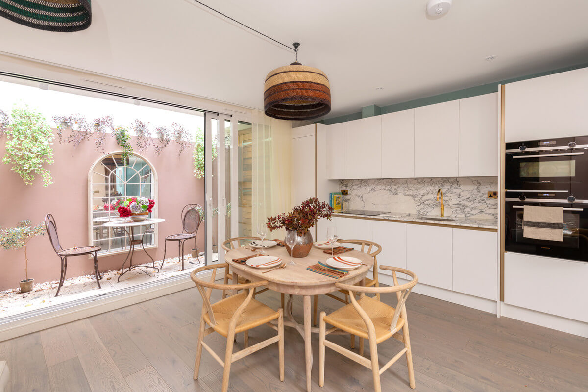A Light London Maisonette in a Former Artist's Studio 10 white kitchen with round dining table