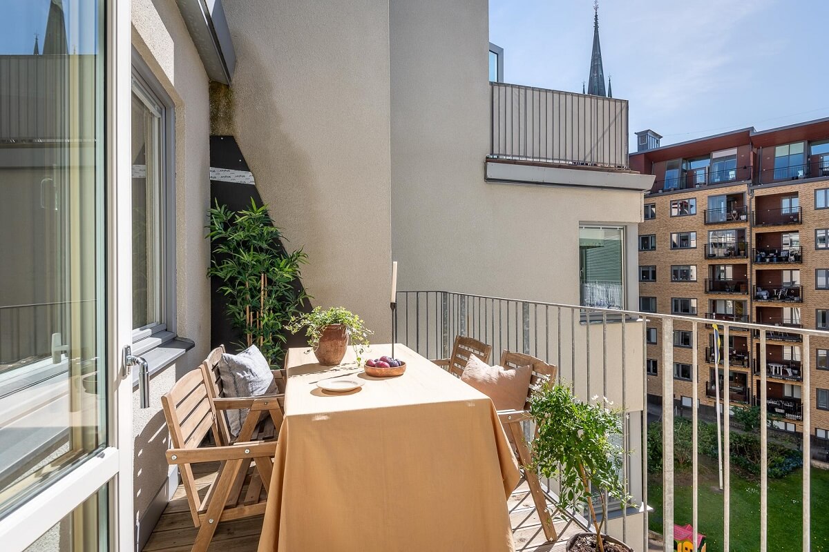 Floor-to-Ceiling Bookcases and Windows in a Loft Style Apartment 14 balcony with dining table