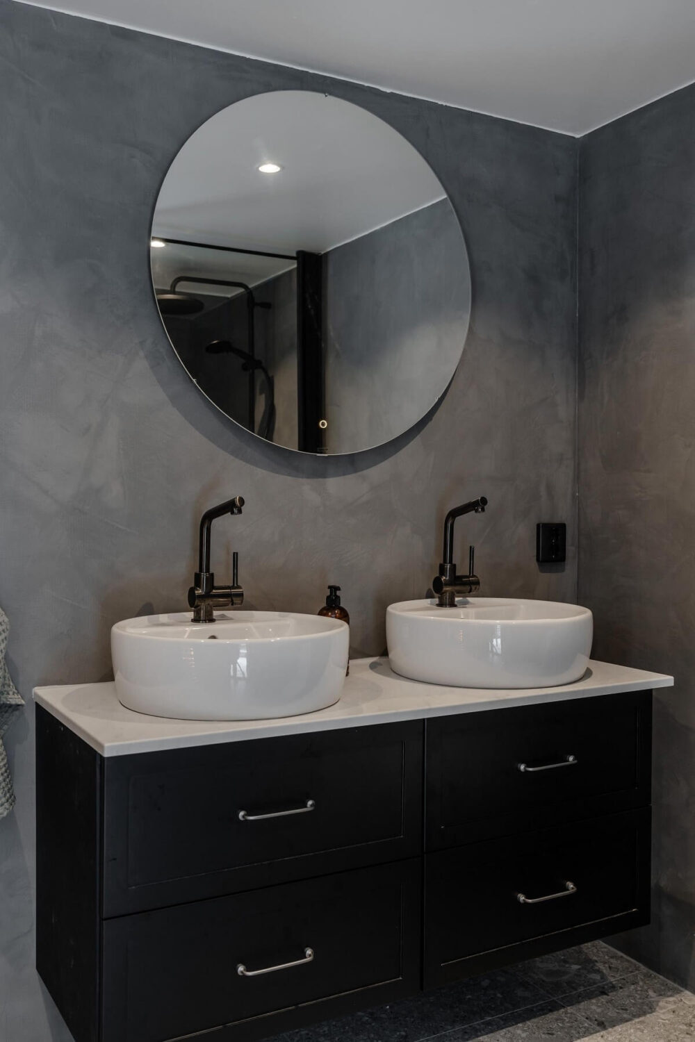 A Gray Swedish Log House Decorated for Christmas 18 bathroom with gray walls black fittings and vanity nordroom