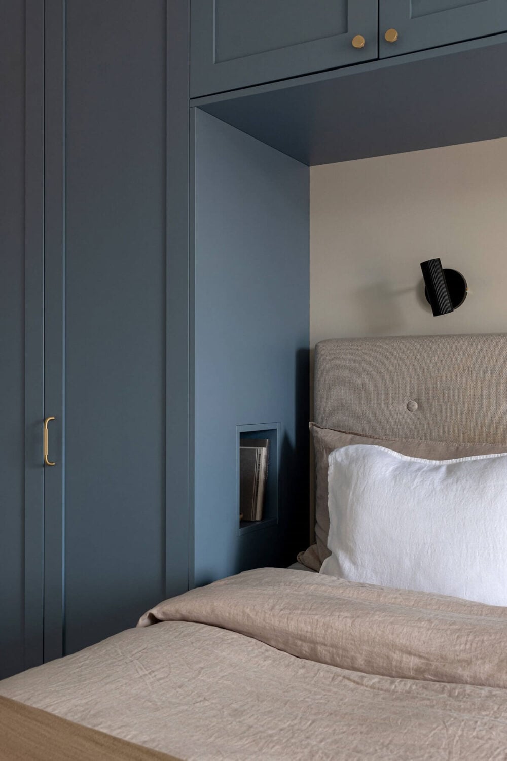 A Stylish Renovated Stockholm Apartment with Built-In Storage 13 bedroom dusty blue wardrobes around bed with storage niche nordroom