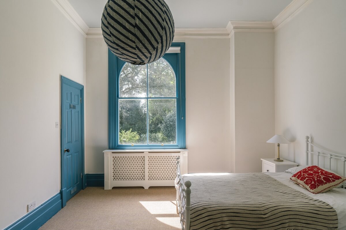 Grand Rooms and Vibrant Colors in an English Country Home 17 bedroom with blue painted joinery