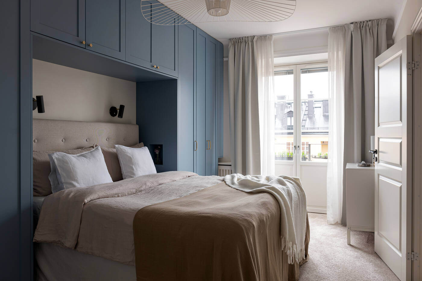 A Stylish Renovated Stockholm Apartment with Built-In Storage 10 bedroom with blue wardrobes in serene apartment