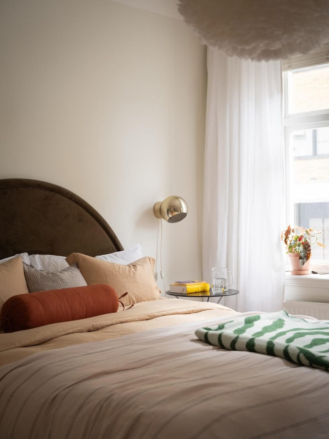 Original Details in a Light-Filled Swedish Apartment 11 bedroom with pink bedding and curved headboard