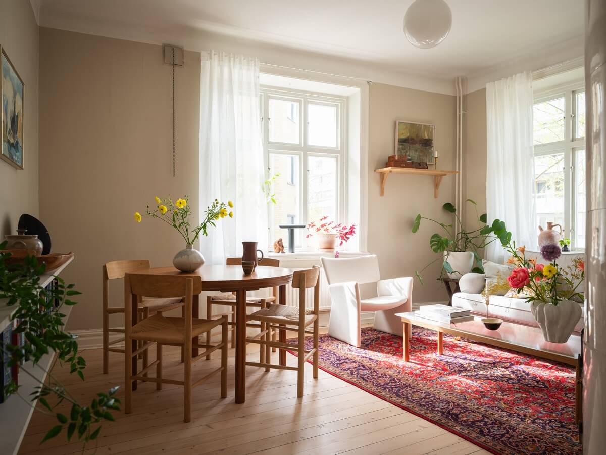 Original Details in a Light-Filled Swedish Apartment 2 beige walls living room with round table and pink rug