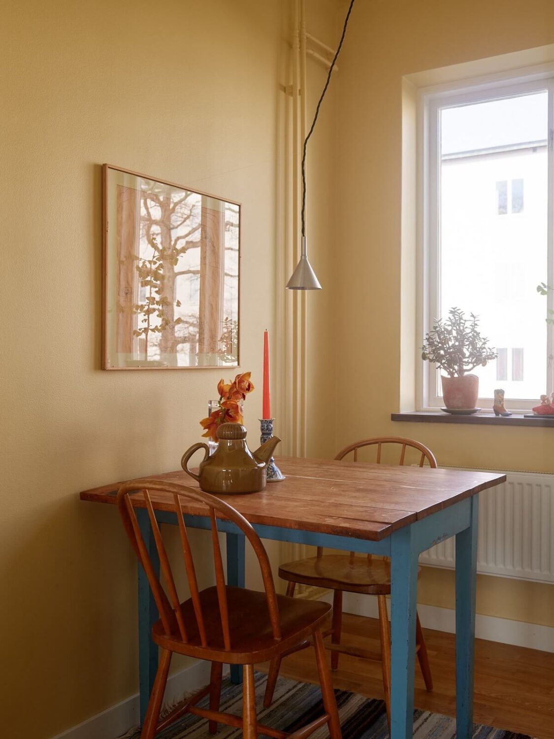 A Swedish Apartment with a Restored Original Kitchen 12 blue kitchen table and yellow walls