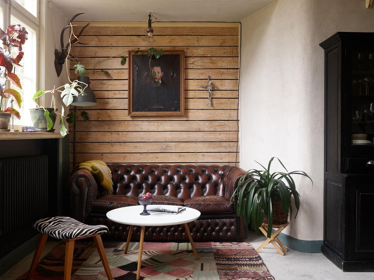 A Charming School Conversion in Sweden 3 cozy sitting area with chesterfield sofa and wooden accent wall