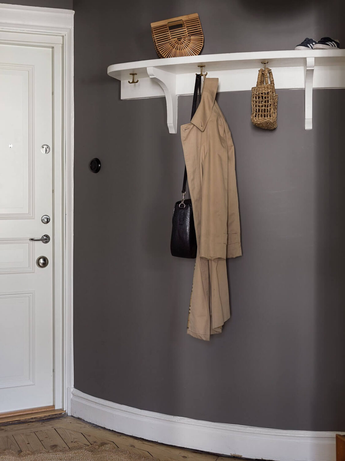 A Gray Stockholm Apartment with a Black Kitchen 19 curved wall with hooks in hallway nordroom