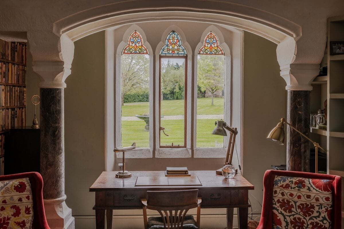 A Charming Gothic-Style Home with Original Details 19 desk in front of window with stained glass nordroom