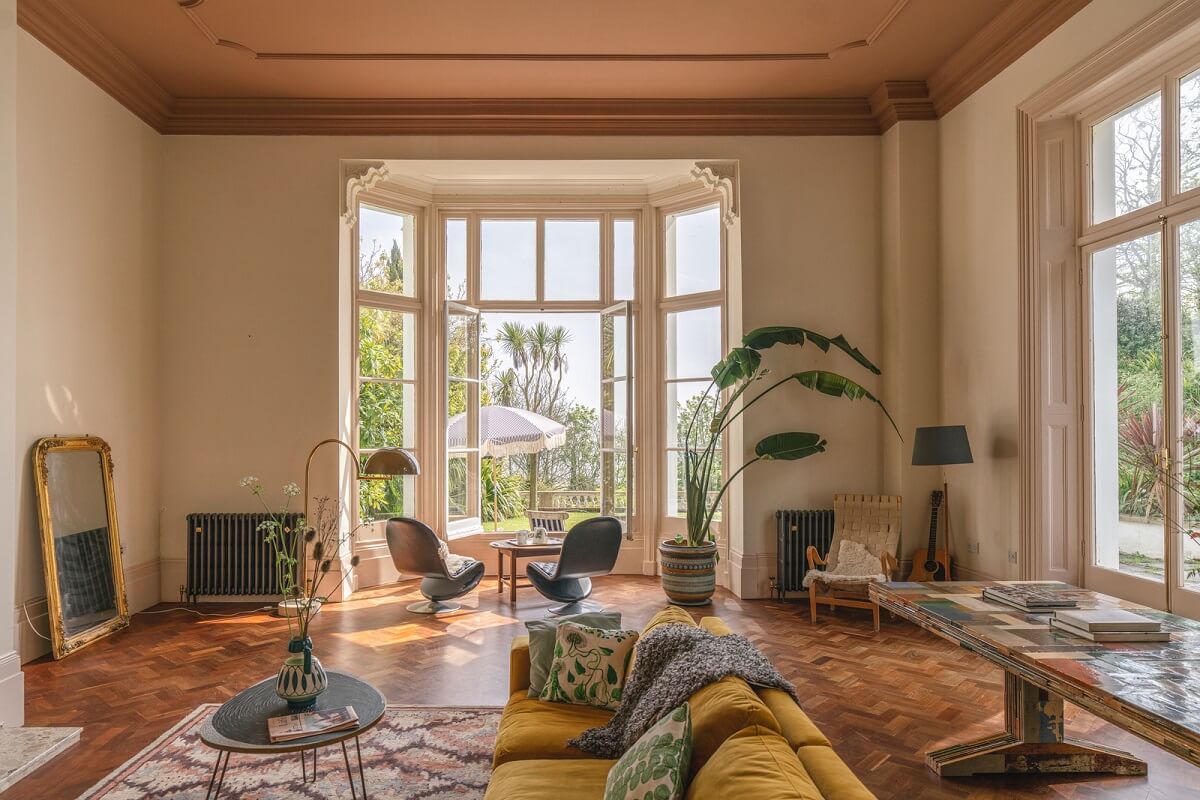 Grand Rooms and Vibrant Colors in an English Country Home 1 grand living room with bay window painted ceiling and ochre sofa nordroom