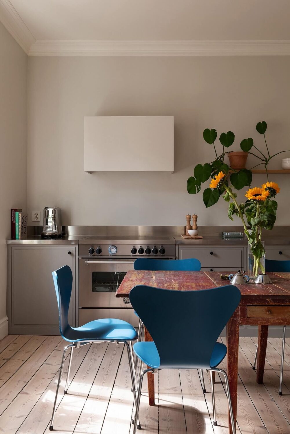 Light Rooms in a Renovated Historic Apartment in Stockholm 10 gray kitchen with blue dining chairs nordroom
