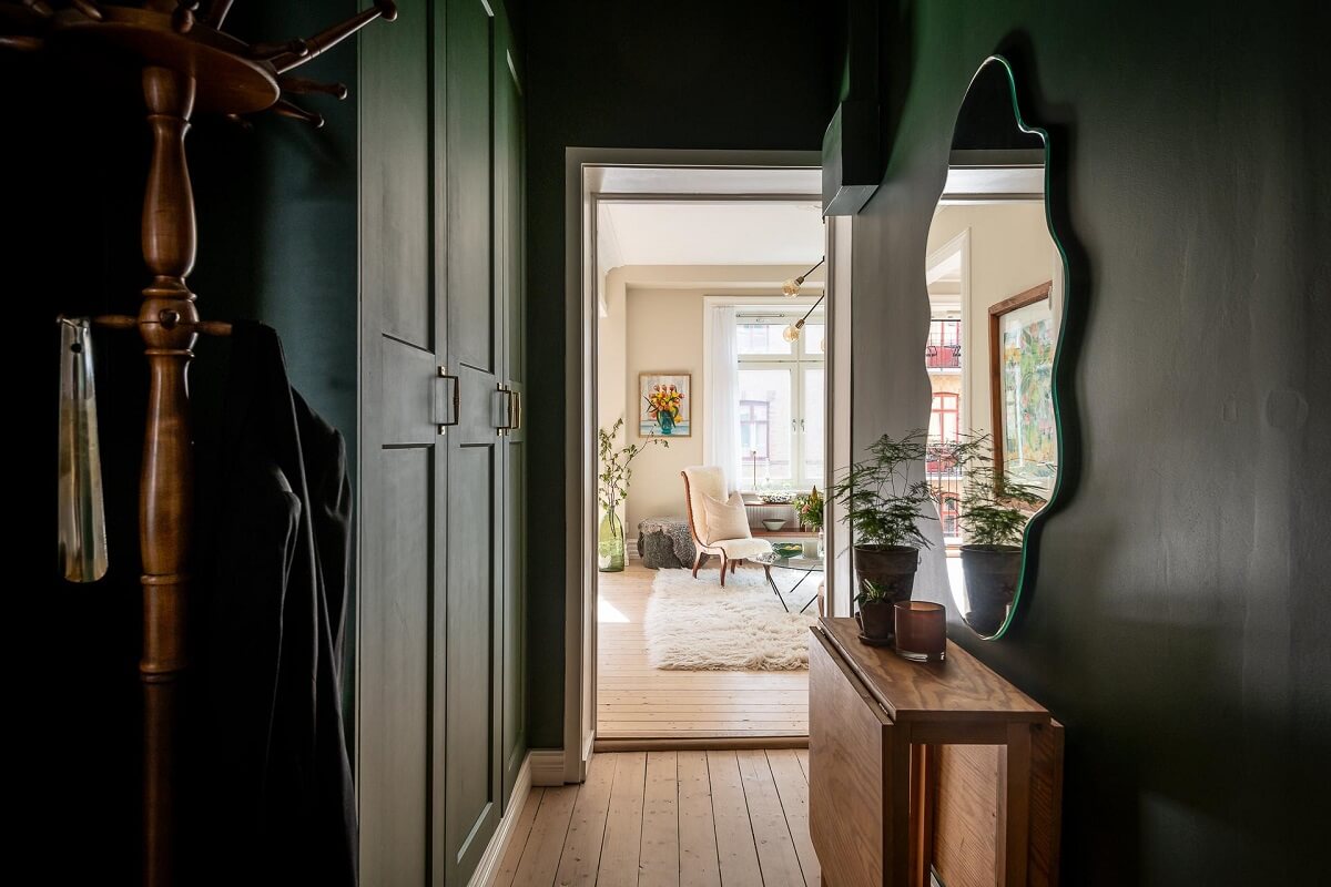 A Turn of the Century Apartment with a Green Kitchen 24 green hallway with cabinets and wavy mirror nordroom