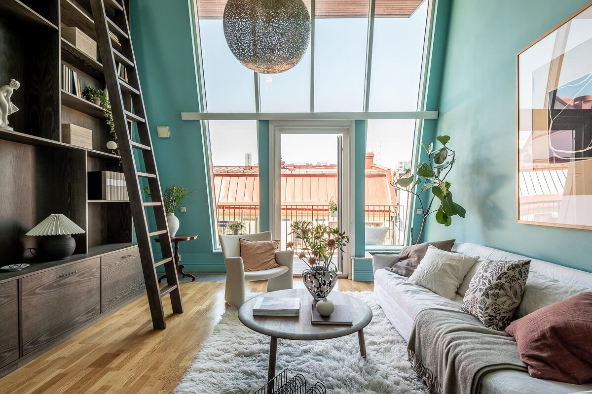 Floor-to-Ceiling Bookcases and Windows in a Loft Style Apartment 2 huge floor to ceiling windows in blue living room