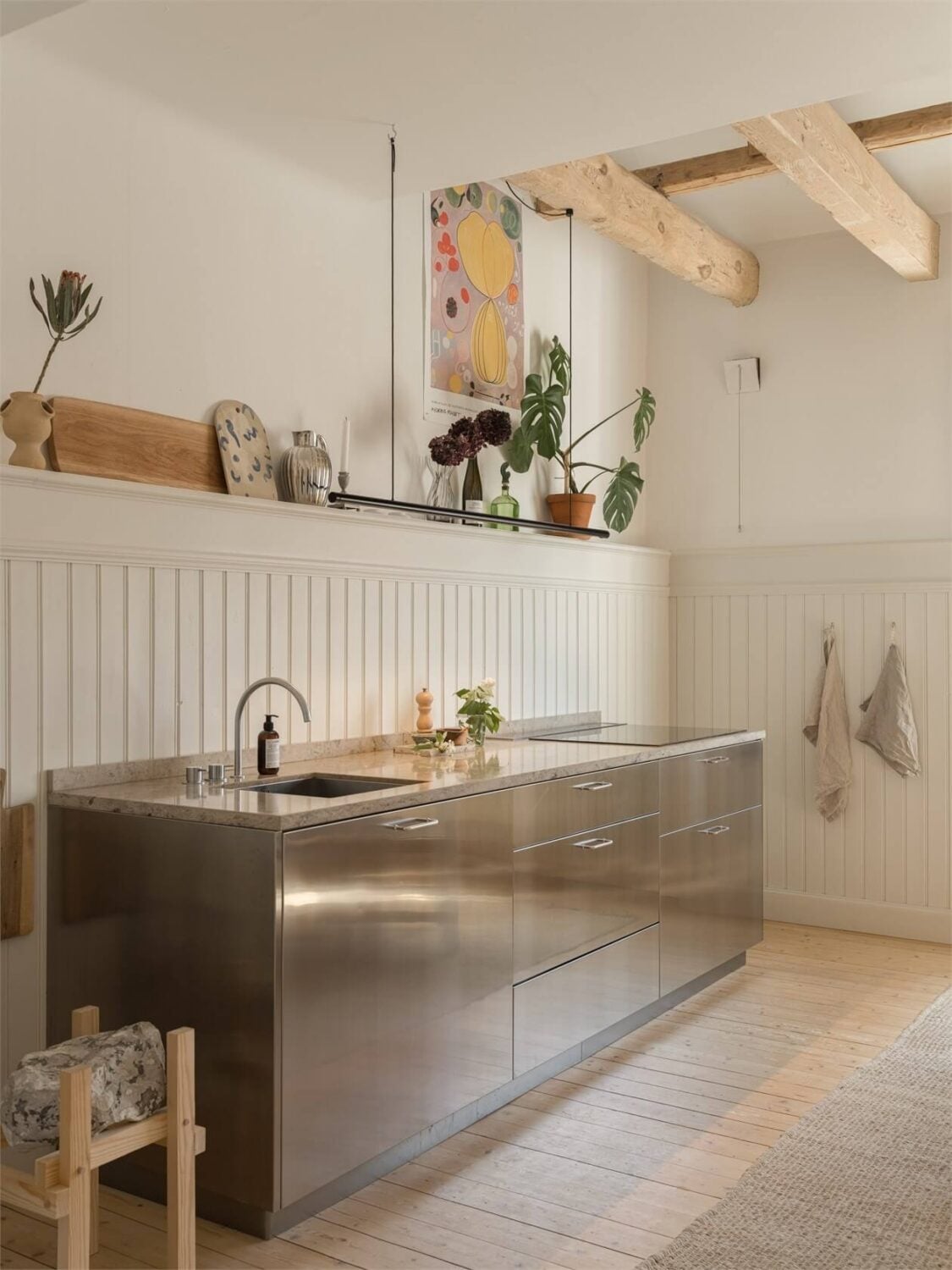 Wooden Details in a Light Duplex Apartment in Sweden 6 kitche with wooden beams and stainless steel cabinets