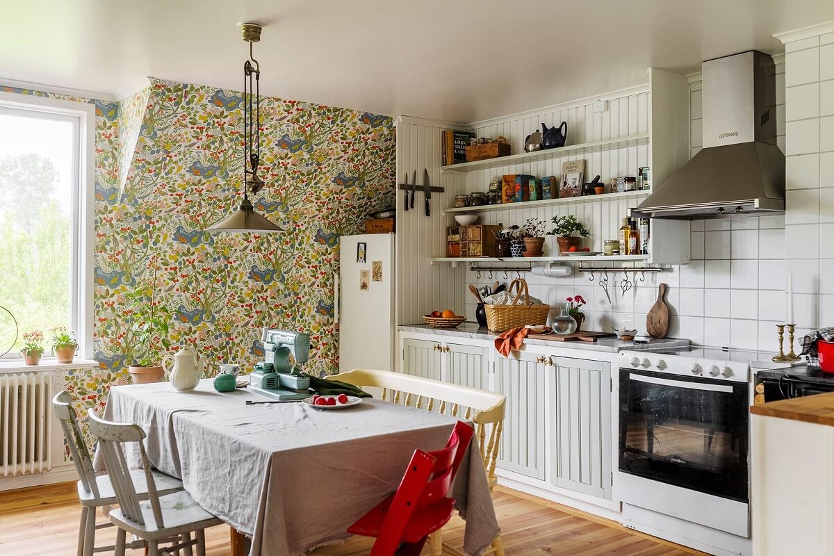 A Historic Swedish Country House with a Beautiful Garden 11 kitchen with colorful wallpaper and mint green cabinets