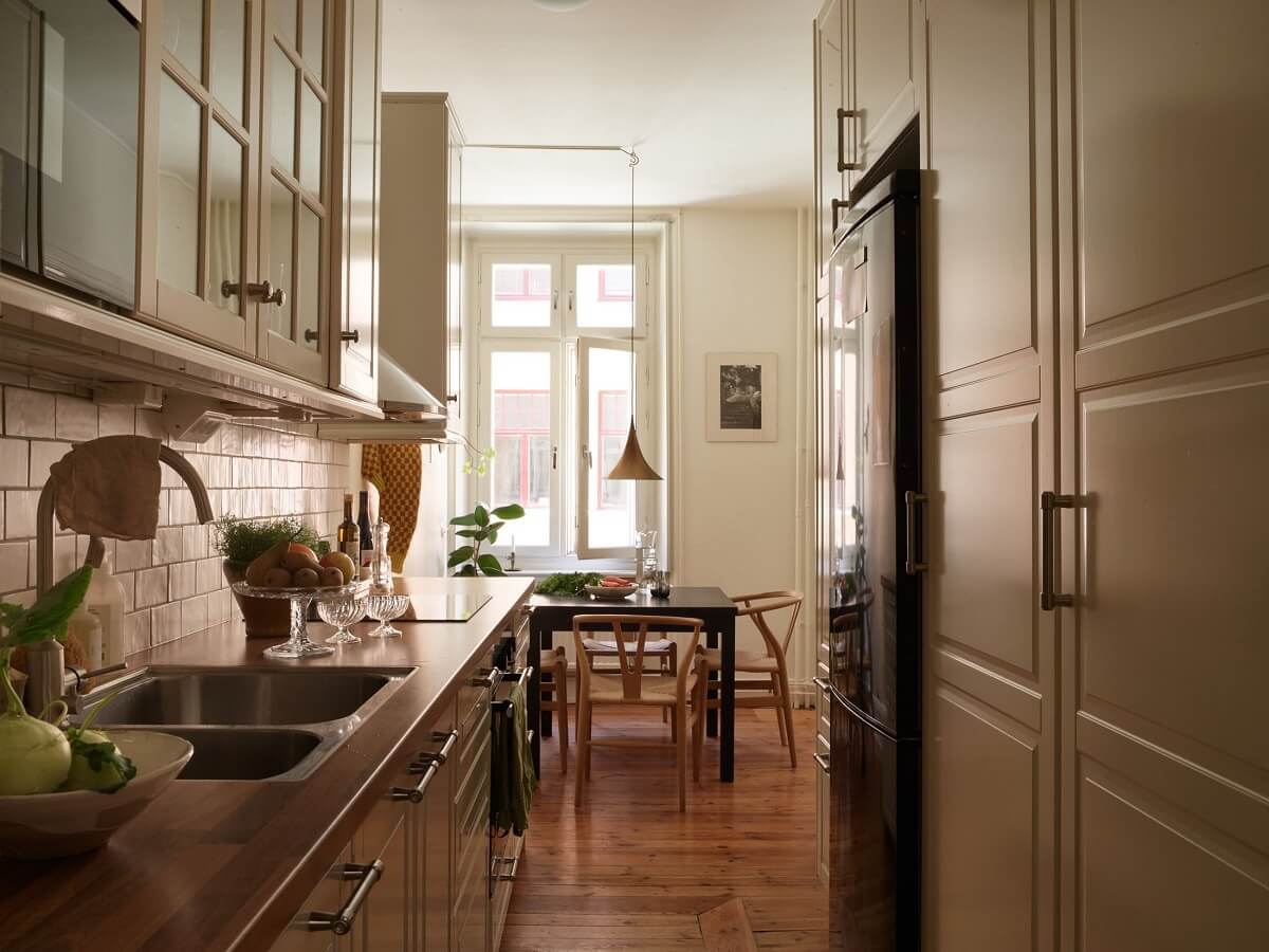 Warm Tones and a Blue Hallway in a Stockholm Apartment 10 kitchen with dining space