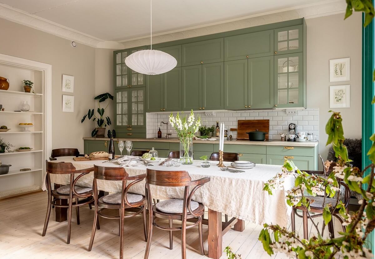 A Turn of the Century Apartment with a Green Kitchen 10 kitchen with large table and green cupboards