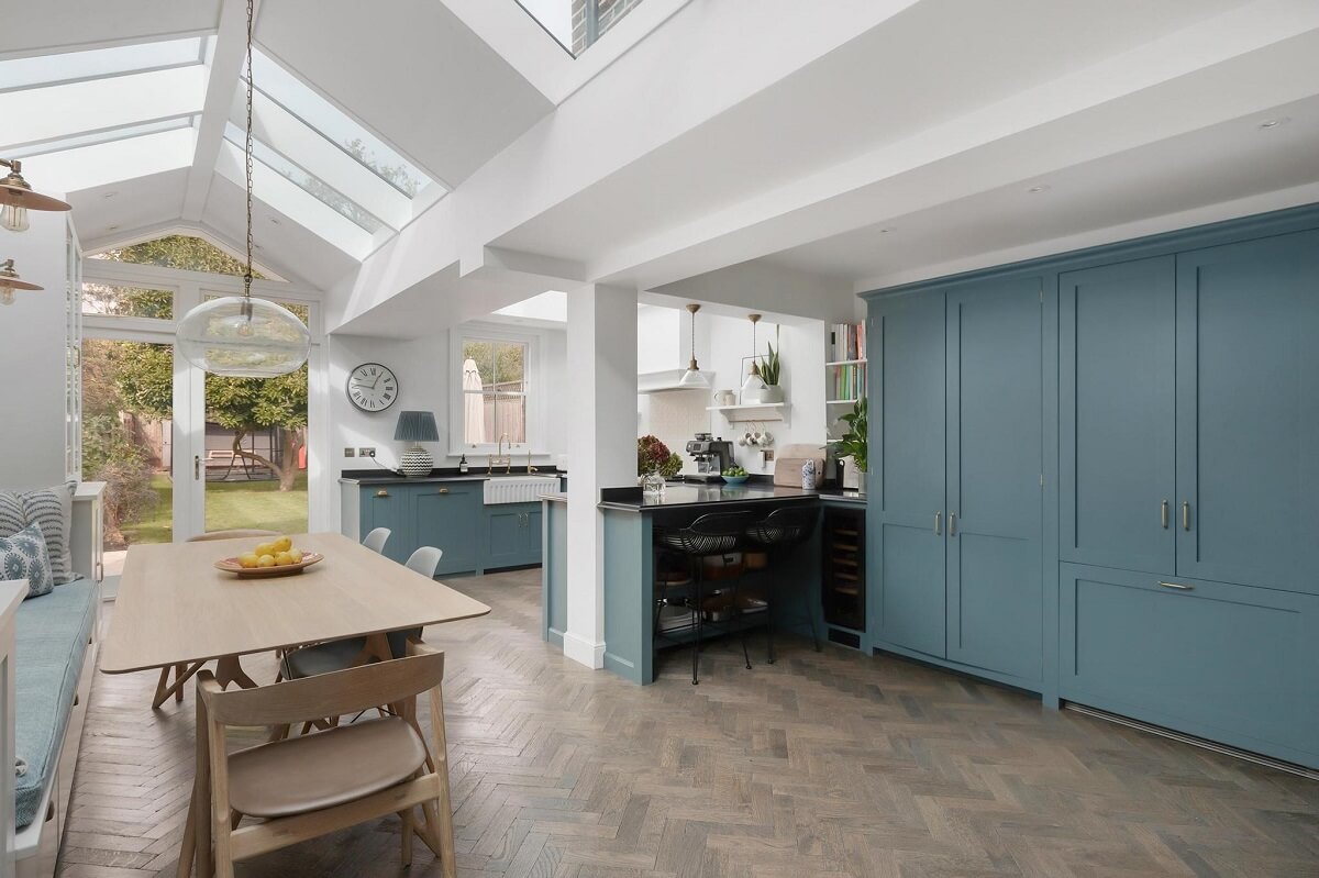 large extended kitchen with blue cabinets and skylights