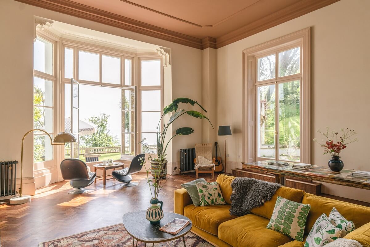 Grand Rooms and Vibrant Colors in an English Country Home 2 large living room with ochre sofa painted ceiling and bay window nordroom