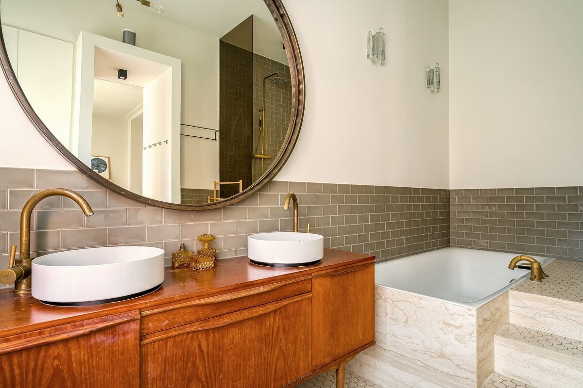 A Colorful Family Home with Open-Plan Spaces in Amsterdam 17 large round mirror and wooden vanity with brass fittings