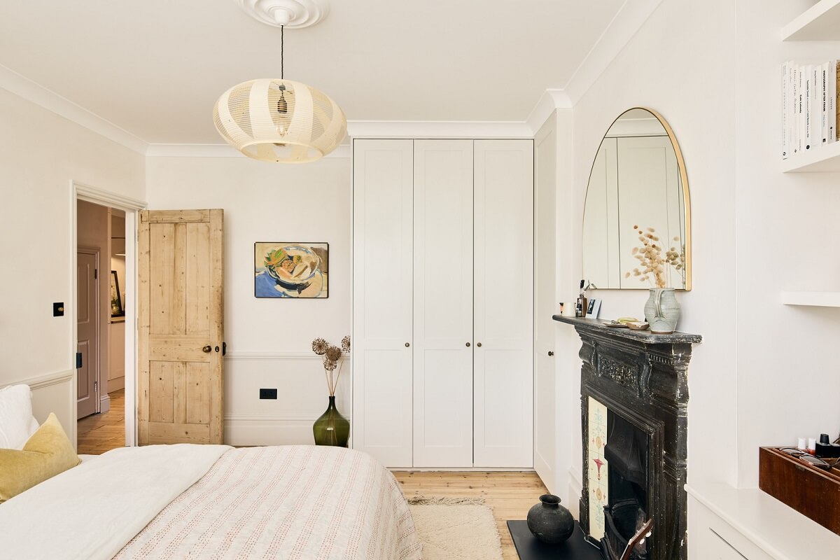 A Light Garden Apartment in London's Poet's Corner 15 light bedroom with black fireplace and built in wardrobes