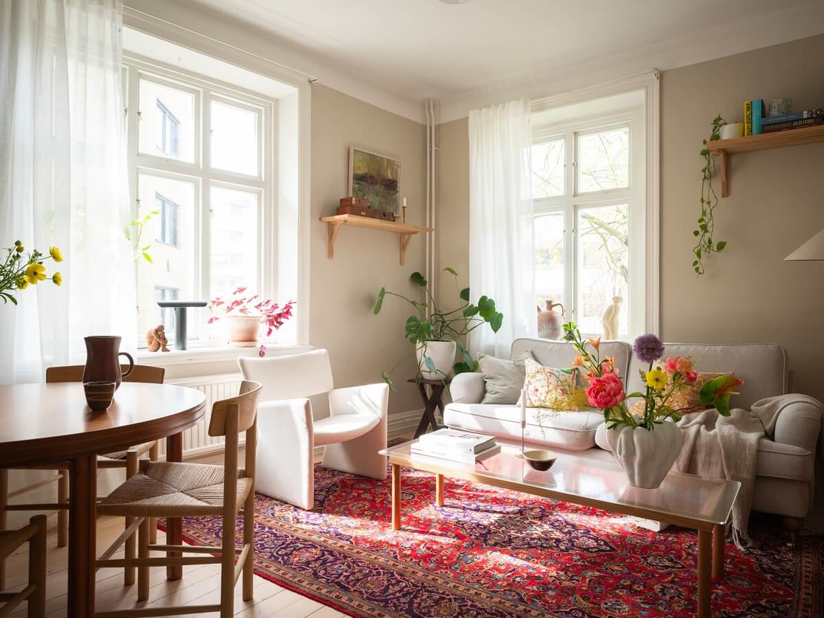 light filled living room with beige walls and pink rug
