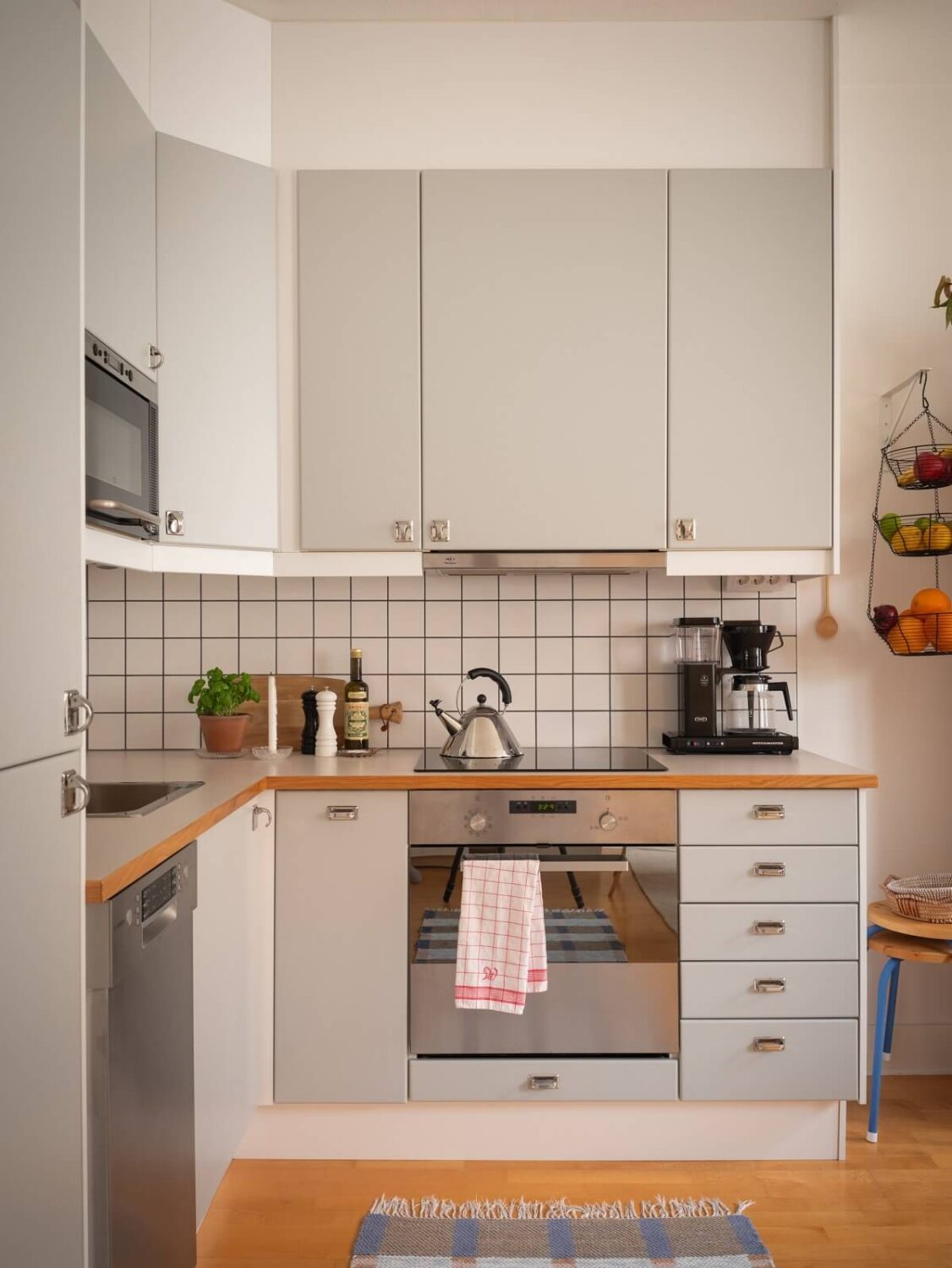 Warm Orange Tones in a Small Apartment 8 light gray kitchen