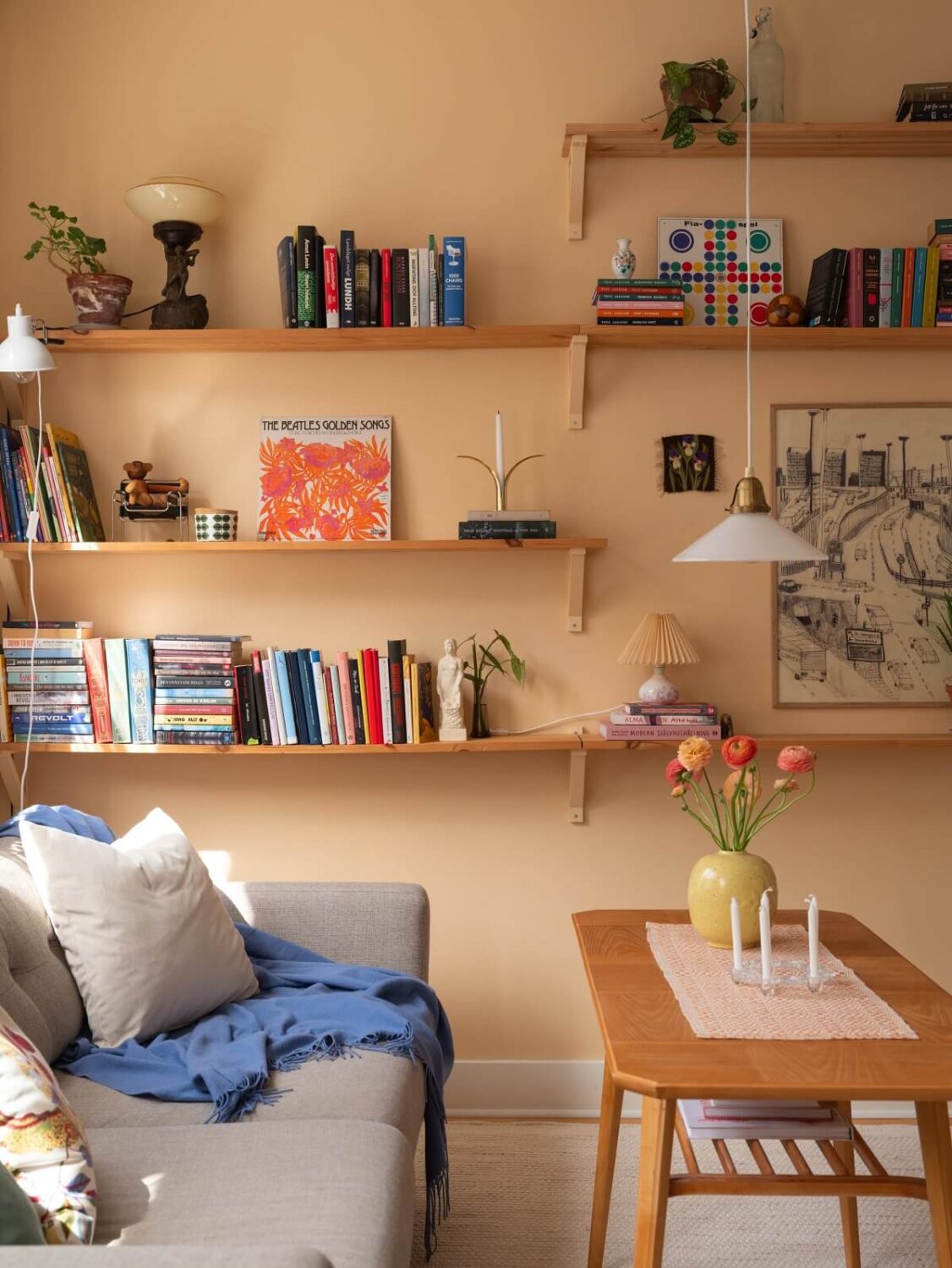 Warm Orange Tones in a Small Apartment 4 living room shelves light orange walls