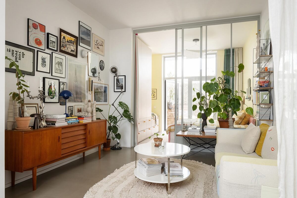 A Unique Basement Apartment in Stockholm 5 living room with gallery wall and midcentury cabinet