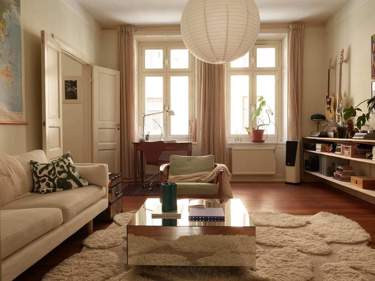 Warm Tones and a Blue Hallway in a Stockholm Apartment 3 living room with large rug and wooden floor