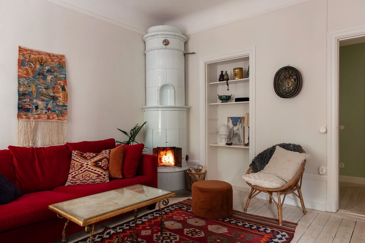 A Swedish Apartment with a Yellow Kitchen 9 living room with red sofa and round fireplace