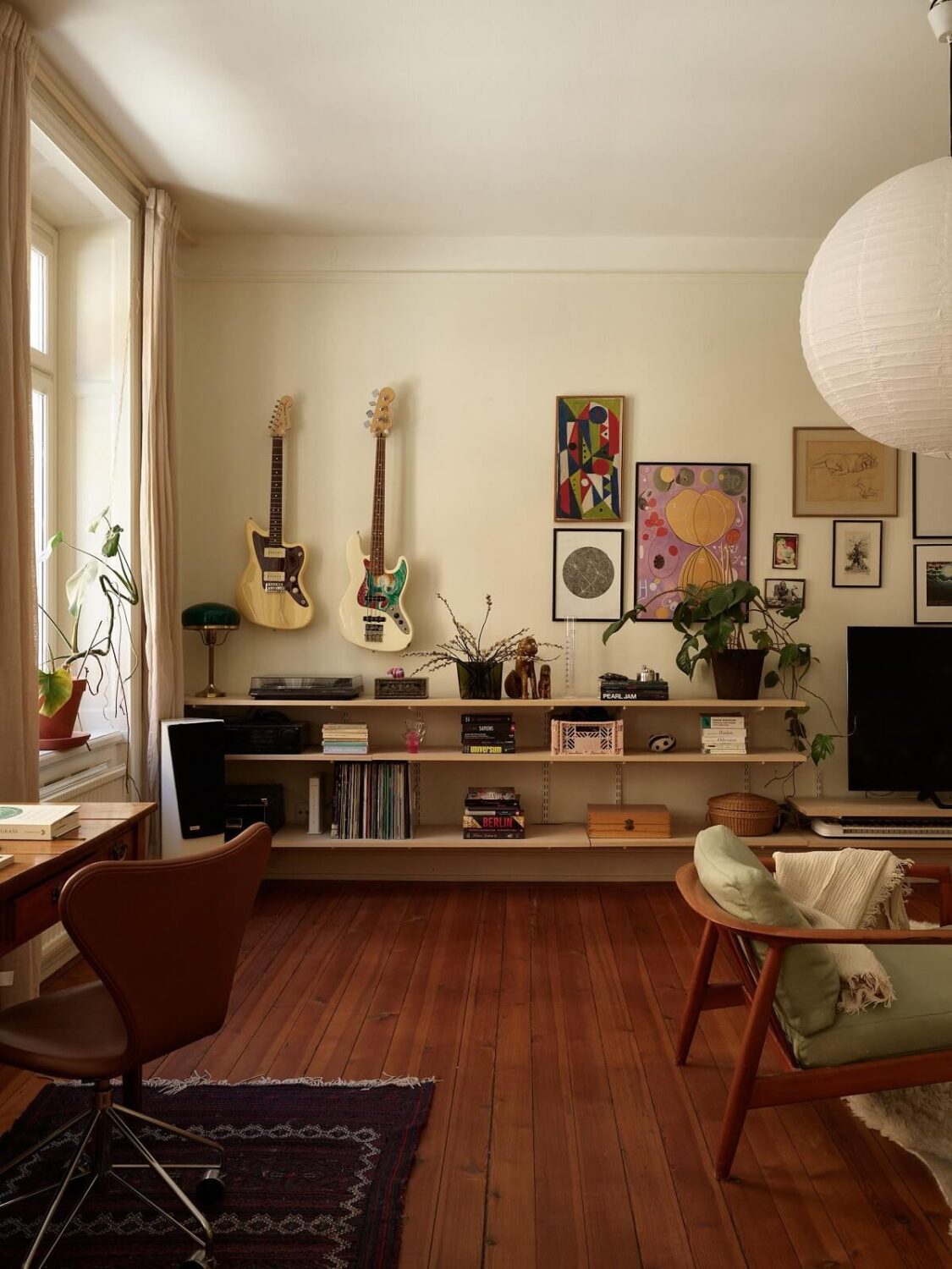Warm Tones and a Blue Hallway in a Stockholm Apartment 1 living room with warm wooden floor and shelves nordroom
