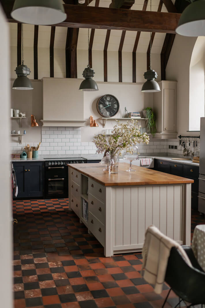 A Charming Gothic-Style Home with Original Details 7 loft style kitchen with checkerboard floor high pitched ceiling wooden beams and island nordroom