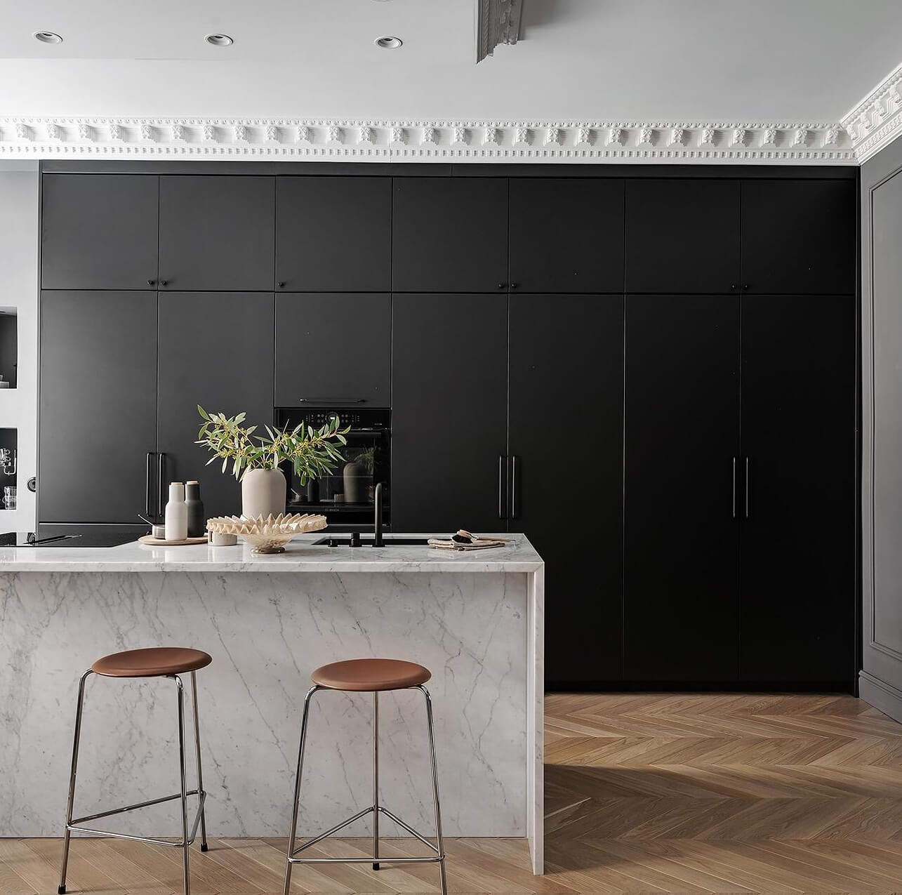 A Luxurious Renovated Apartment with Dark Gray Walls 9 marble kitchen island and wall of cabinets
