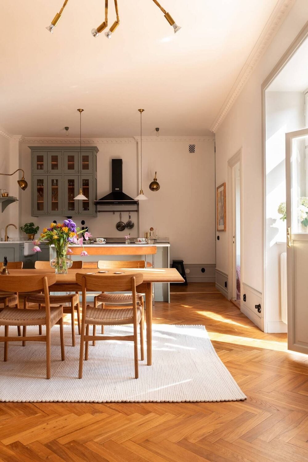 An Elegant Turn-of-the-Century Apartment in Stockholm 7 open plan kitchen dining room with herringbone floor nordroom