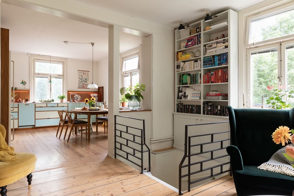 A Swedish Duplex with a Unique Wood and Pastel Colored Kitchen 12 open plan living room and kitchen with bookshelves