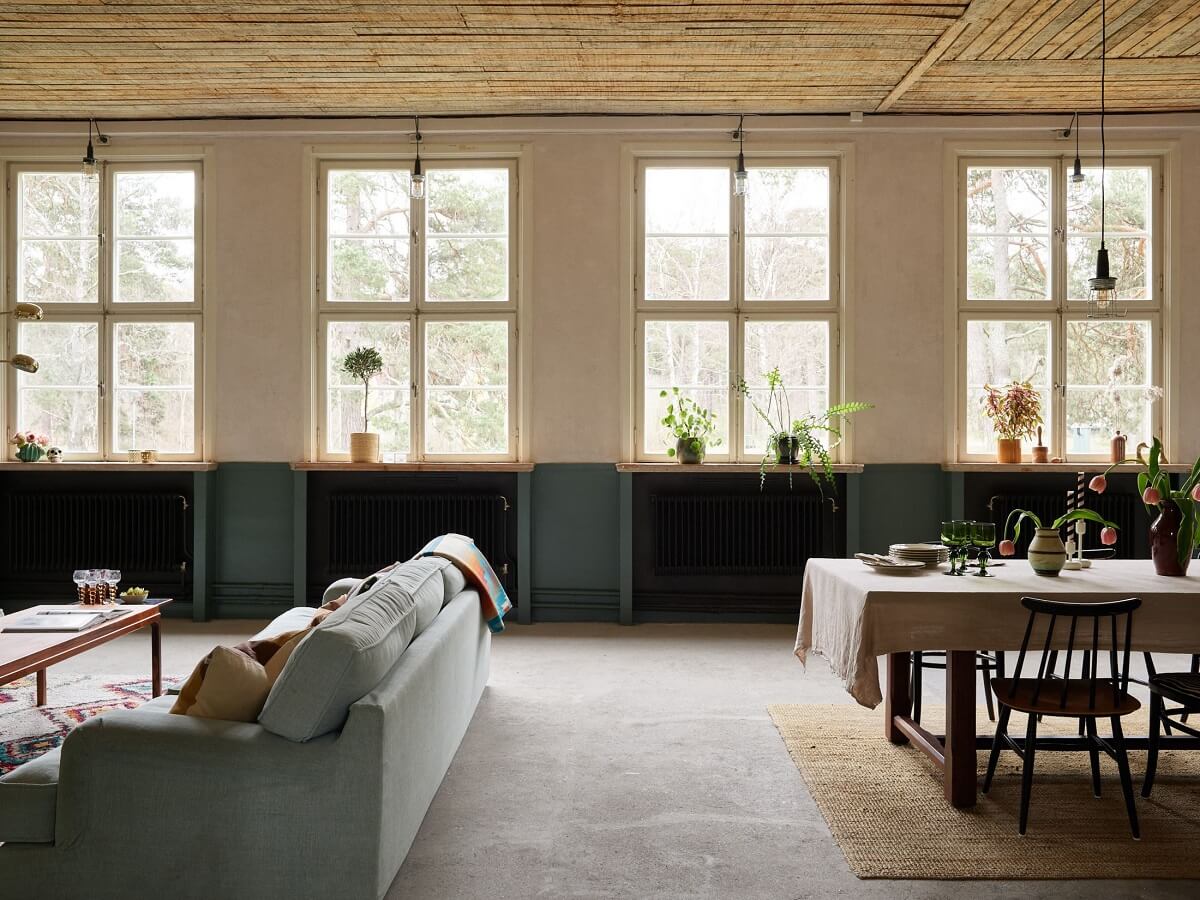A Charming School Conversion in Sweden 9 open plan living room dining table wooden ceiling school conversion