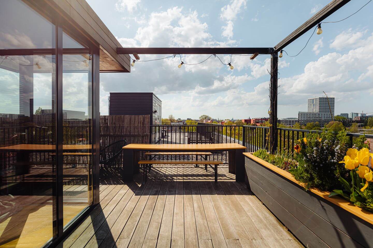 A Modern Loft-Style School Conversion in Amsterdam 28 roof terrace with dining table