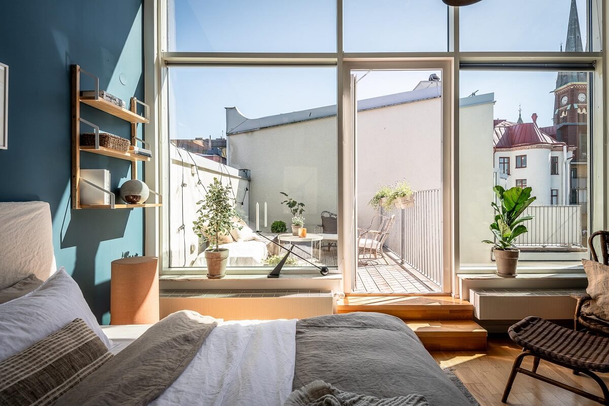Floor-to-Ceiling Bookcases and Windows in a Loft Style Apartment 18 scandi bedroom with blue walls large windows and roof terrace