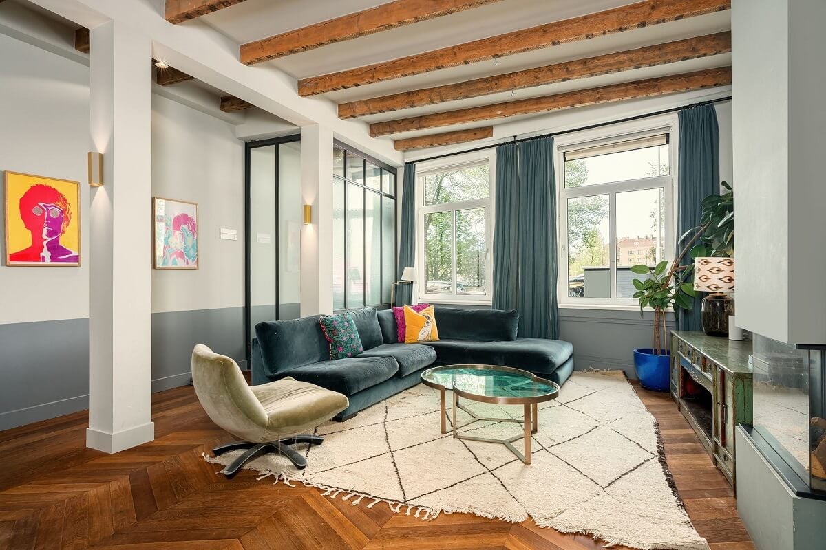 A Colorful Family Home with Open-Plan Spaces in Amsterdam 9 sitting room with chevron floor blue sofa and wooden beams