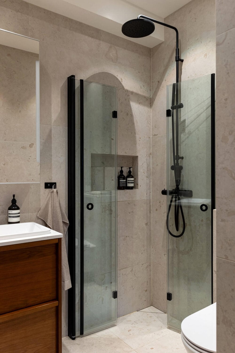 A Stylish Renovated Stockholm Apartment with Built-In Storage 19 small bathroom with gray tiles and black fittings nordroom
