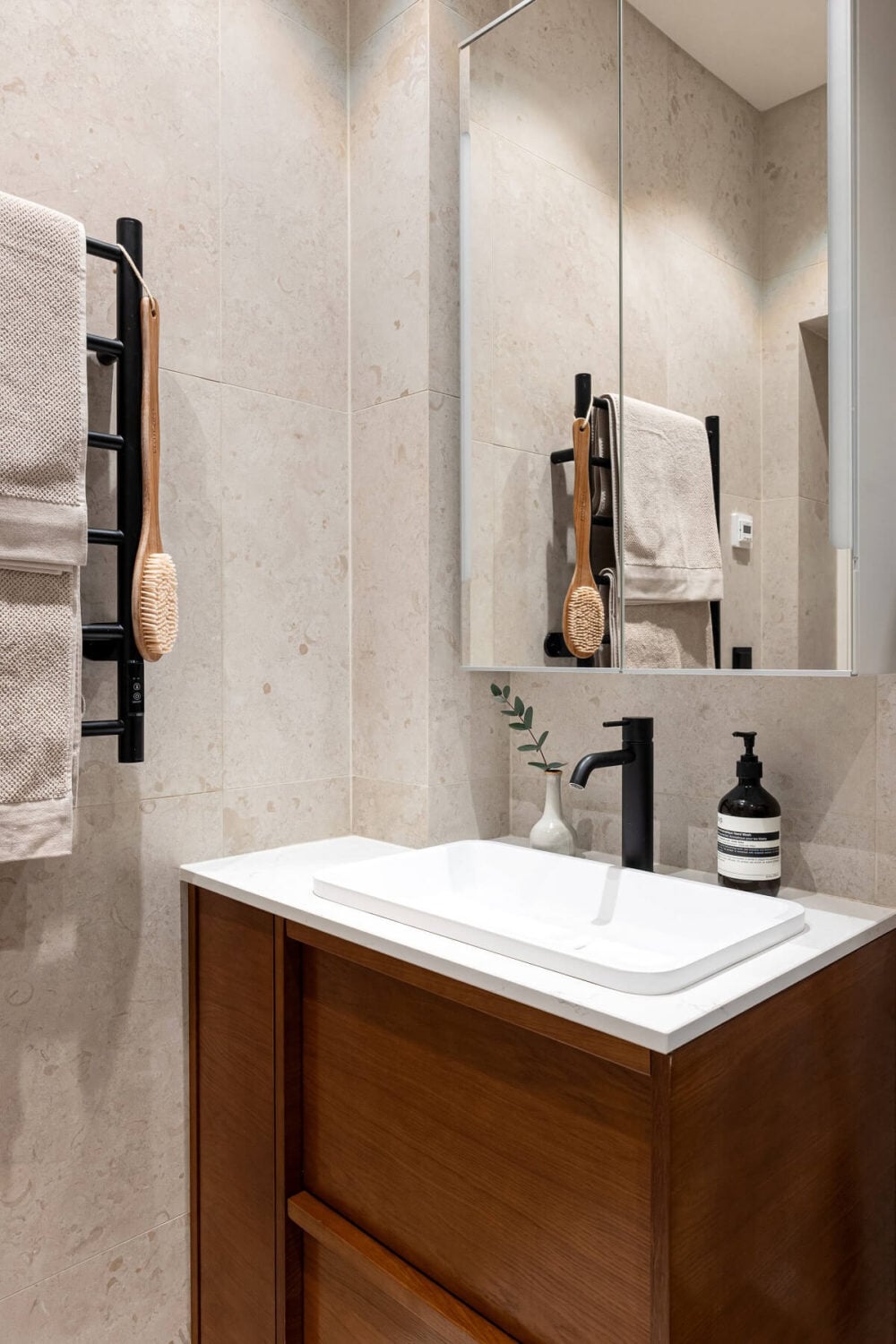 A Stylish Renovated Stockholm Apartment with Built-In Storage 20 small bathroom with wooden vanity and black taps