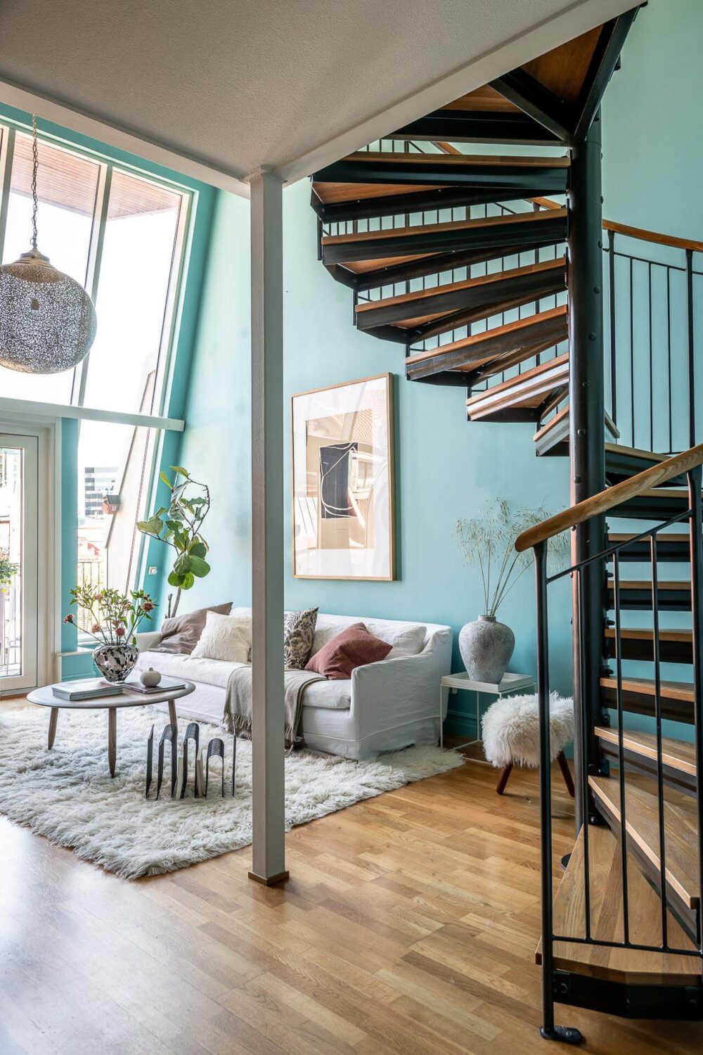 Floor-to-Ceiling Bookcases and Windows in a Loft Style Apartment 4 spiral staircase and vibrant blue walls in living room nordroom