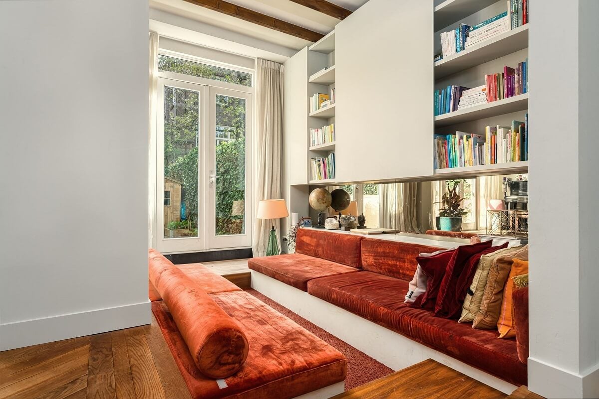 A Colorful Family Home with Open-Plan Spaces in Amsterdam 3 sunken sitting area with red upholstered built in sofa