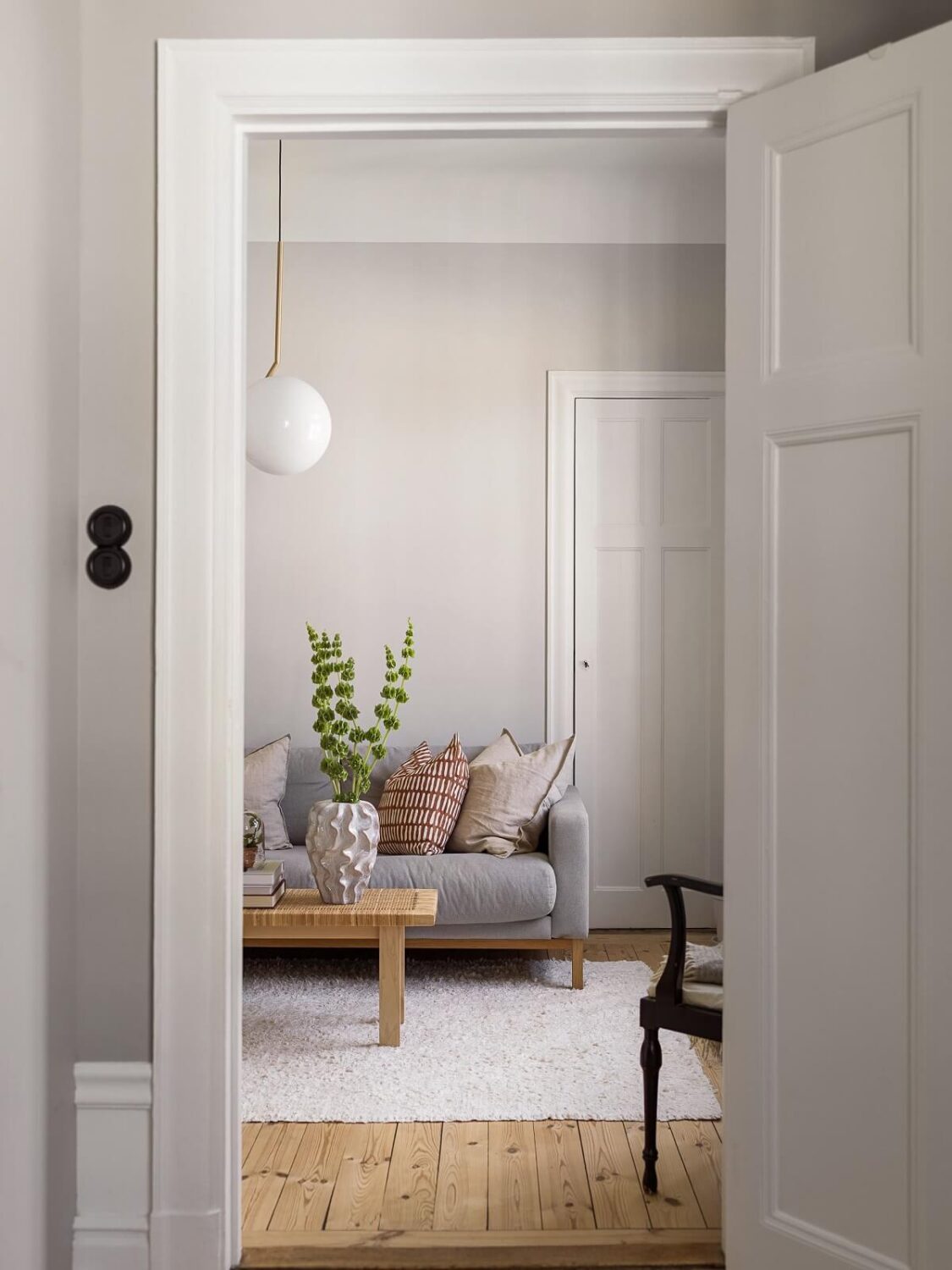 A Gray Stockholm Apartment with a Black Kitchen 3 view into light gray living room nordroom