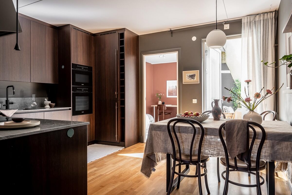 Floor-to-Ceiling Bookcases and Windows in a Loft Style Apartment 11 walnut kitchen with dining table nordroom