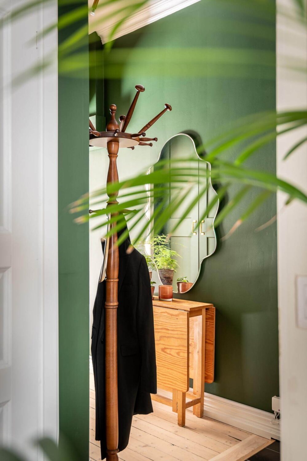 A Turn of the Century Apartment with a Green Kitchen 23 wavy mirror in green hallway nordroom